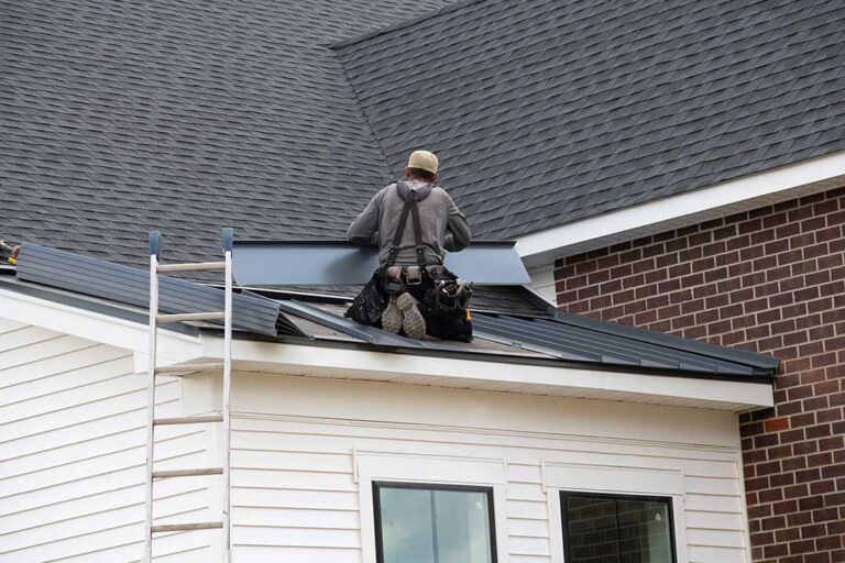 Roof shingles and attic framing showing condensation and damp insulation beneath the roof deck.