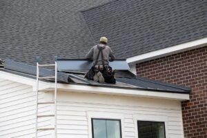Wind-lifted shingles and fallen branches visible on a residential roof after a severe storm.